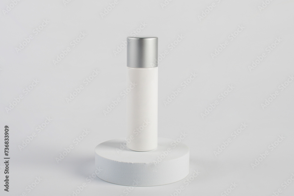Plastic white tube for cream or lotion. Skin care or sunscreen cosmetic with stylish props on white background 