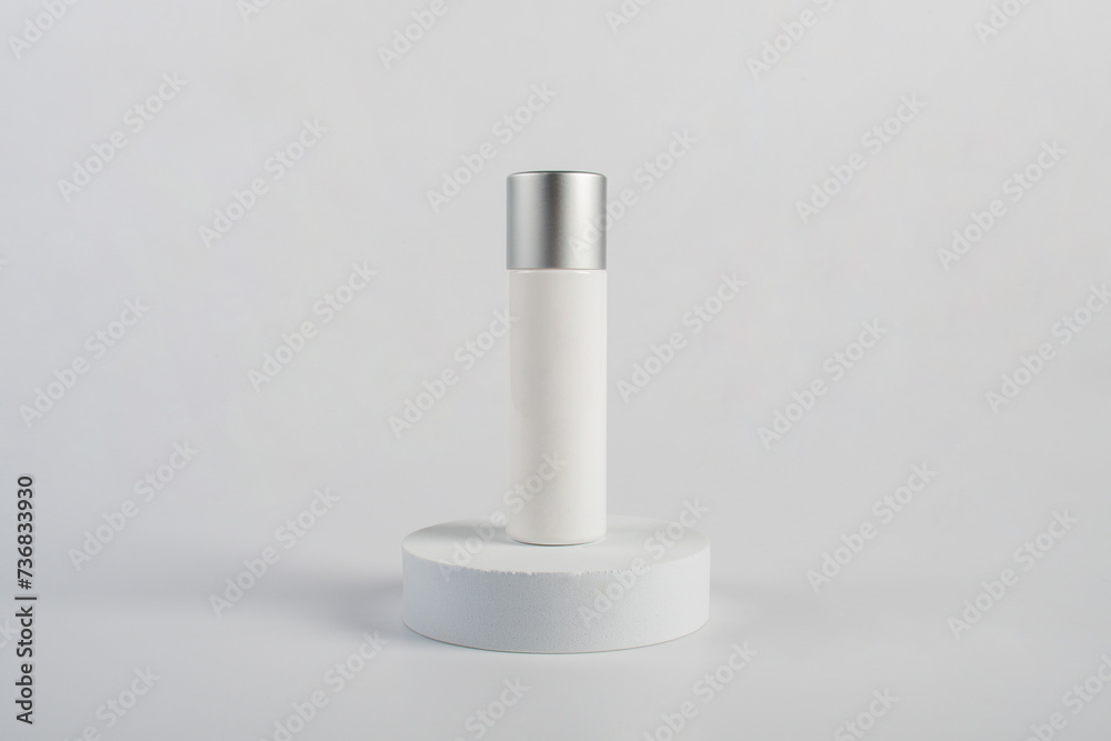 Plastic white tube for cream or lotion. Skin care or sunscreen cosmetic with stylish props on white background 