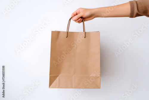Hand Holding Blank Brown Paper Bag on White Background. Eco-Friendly Shopping Concept