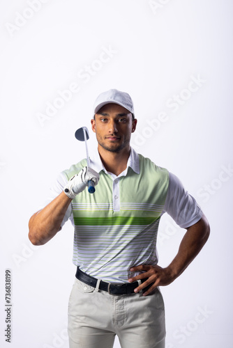 Young biracial man poses confidently with a golf club