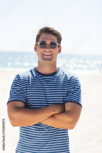 Caucasian man smiles on a sunny beach day, unaltered