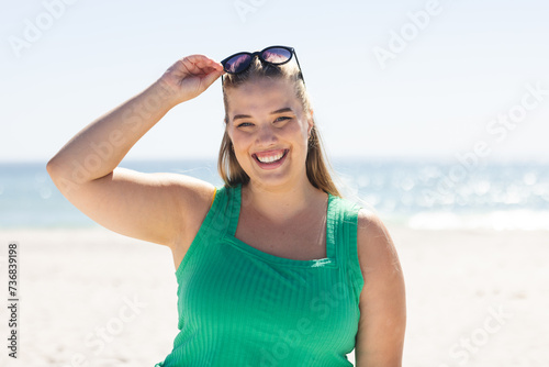 Young plus size Caucasian woman enjoys a sunny beach day