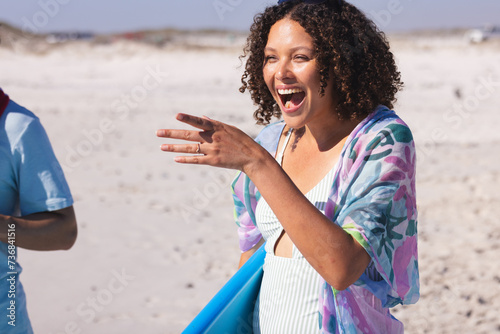 Young biracial woman laughs joyfully at the beach