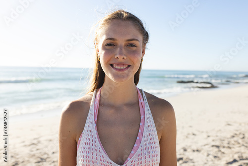 Young Caucasian woman smiles brightly on a sunny beach day