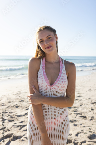 Young Caucasian woman stands on a sunny beach