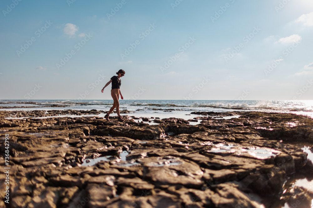 girl walks along a rocky beach. walk along the sea.