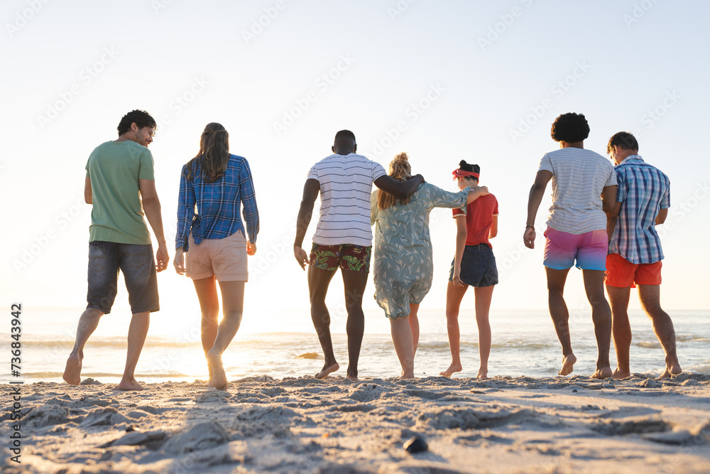 Fototapeta premium Diverse group of friends enjoy a beach sunset