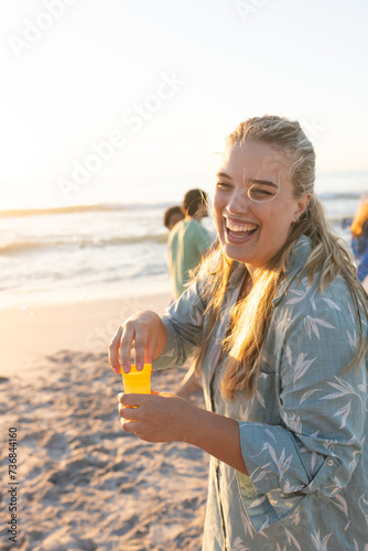 Young Caucasian woman enjoys a sunny beach day, with copy space