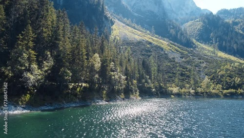 Aerial drone shot captures the pristine beauty of Lake Hallstaetter in the heart of the Alps. Crystal-clear waters mirror the stunning alpine surroundings, creating a breathtaking vista from above photo