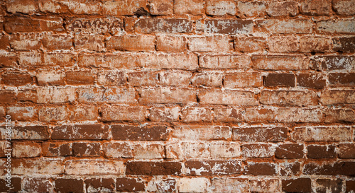 The texture of an old brick wall. The surface of the wall is damaged. A rough brick Wall made of old bricks. Grunge Wall Background.