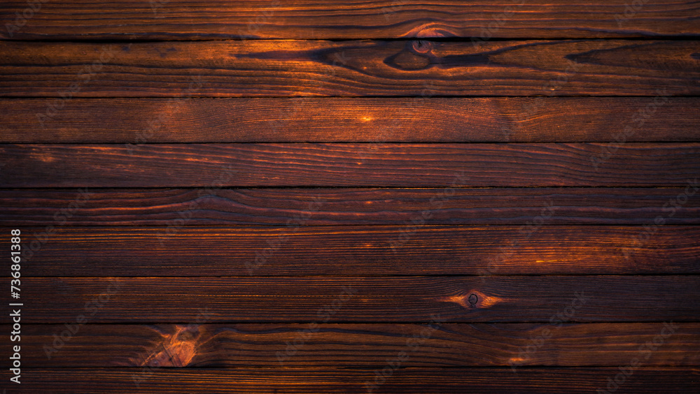 Burnt wooden background made of slats. A gloomy wooden surface with cracks. The texture of the tree. Burnt wooden background made of slats. A gloomy wooden surface with cracks. The texture of the tree.