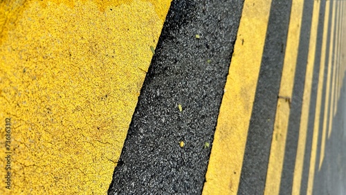 Low angle photo of yellow stripes sign on the asphalt as warning sign for pedestrian crossing photo