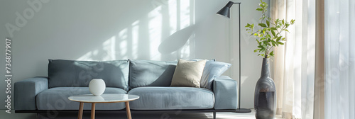 Elegant living room interior with a sofa, a lamp and a table close to a window for natural light