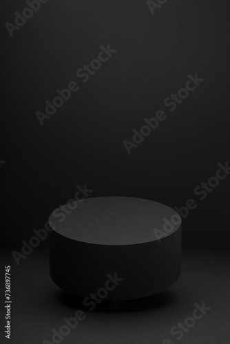 Soaring black round podium, mockup on black background, shadow, vertical. Template for presentation cosmetic products, gifts, goods, advertising, design, display, showing in exquisite modern style.