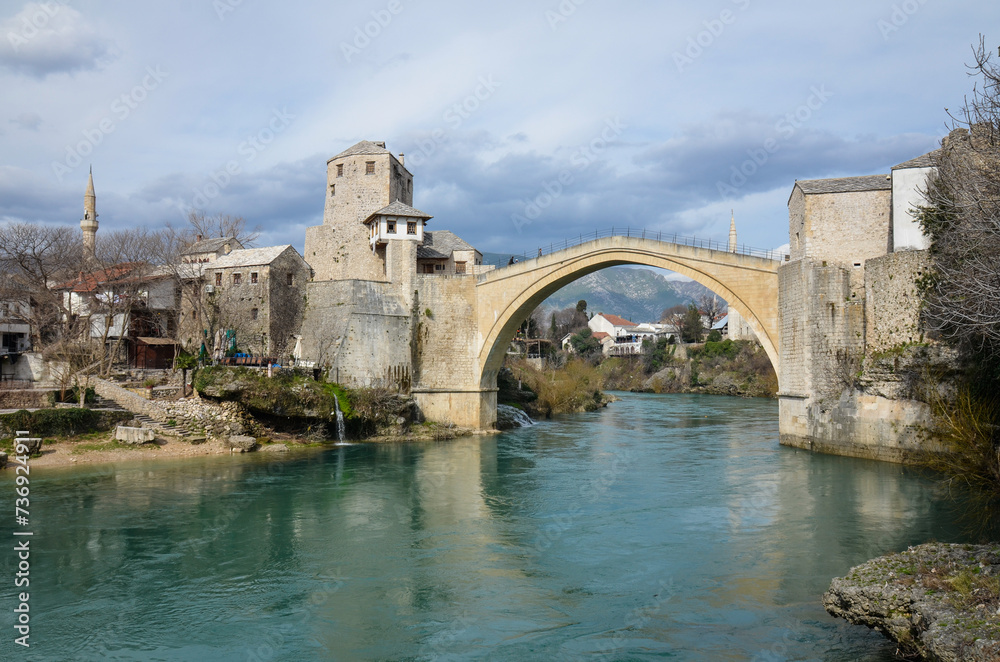 View of the Old Bridge in Mostar city in Bosnia and Herzegovina. Neretva river. Unesco World Heritage Site. People walking over the bridge.