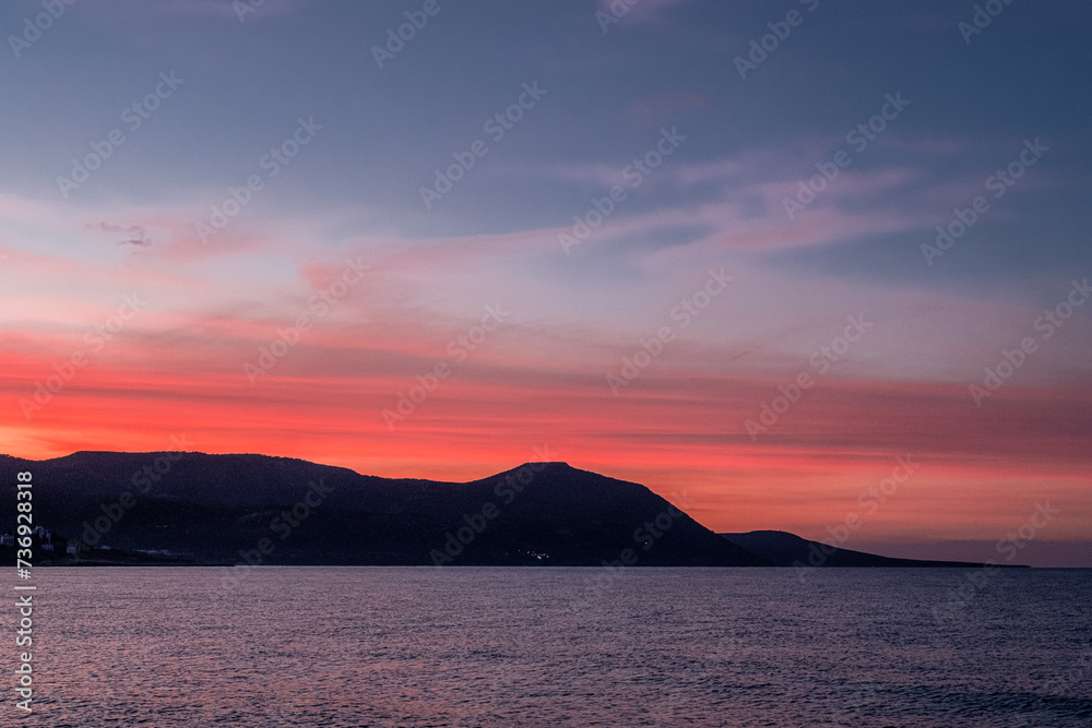 View of the Sunset at Chrysochou Bay as seen from Latsi village harbor, located by the sea, near Neo Chorio village, Akamas Peninsula, Cyprus 