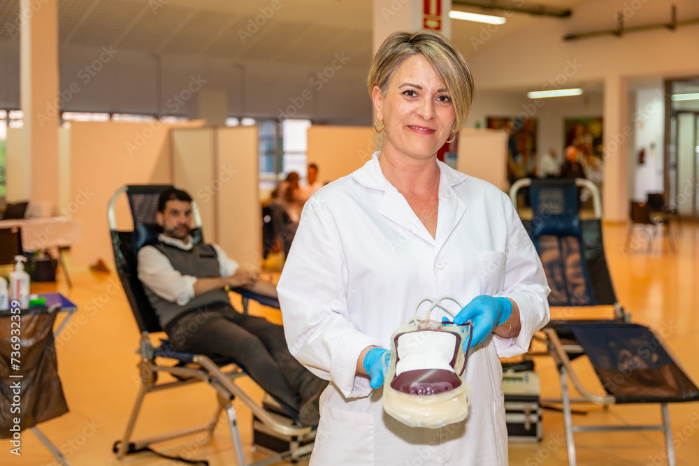 Nurse with bag filled of blood in a donation center Nurse with bag filled of blood in a donation center