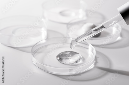 Petri dish and dropper on white background. Dripping gel.
