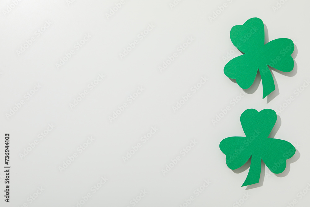 Green paper clover leaves on white background, space for text Green paper clover leaves on white background, space for text