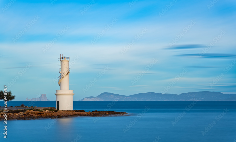 Iconic Lighthouse Exposure in Formentera with Es Vedra Silhouetted in Background Iconic Lighthouse Exposure in Formentera with Es Vedra Silhouetted in Background