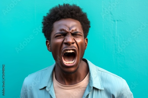 African American man, his stance aggressive, lips curled in a snarl, reacting to a confrontation on the street, captured against a solid pastel turquoise background.