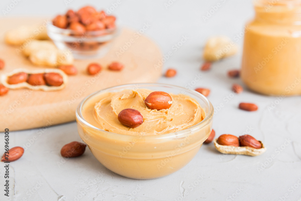 Bowl of peanut butter and peanuts on table background. top view with copy space. Creamy peanut pasta in small bowl Bowl of peanut butter and peanuts on table background. top view with copy space. Creamy peanut pasta in small bowl