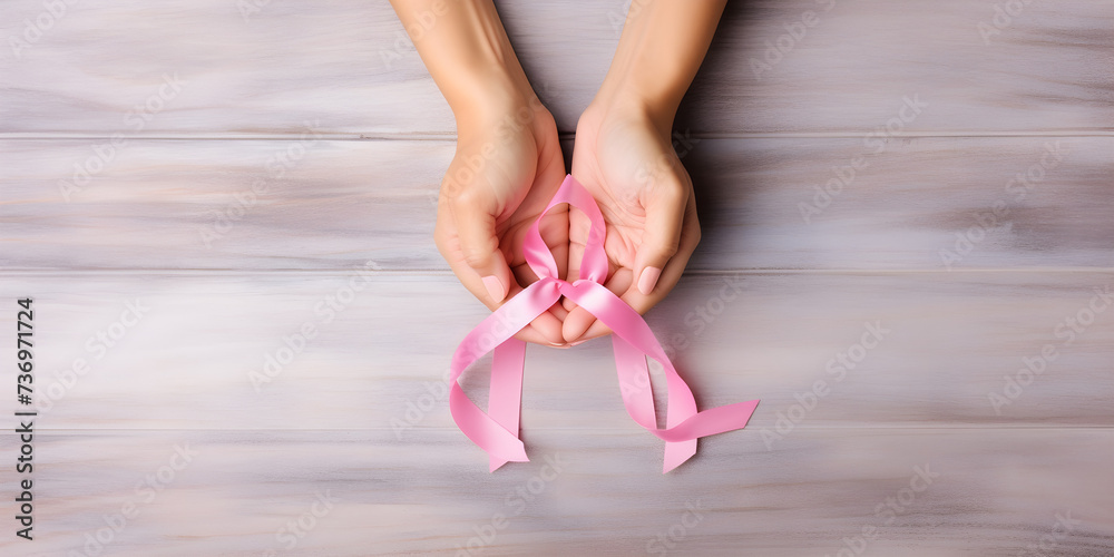 Hands holding pink ribbon, breast cancer october pink awareness.