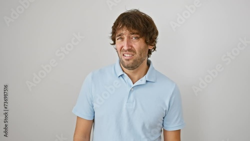 Stunned young caucasian guy sportin' skeptic face; a look of disbelief, mouth agape in surprise. picture of him standing, taken against plain white isolated background. photo