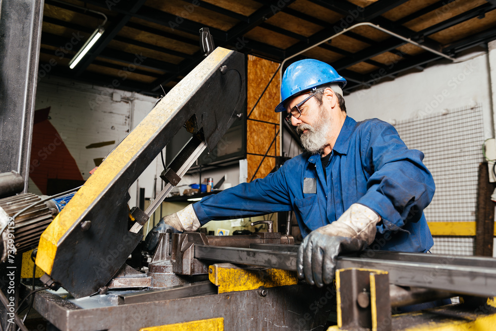 Senior bearded man working in factory workshop