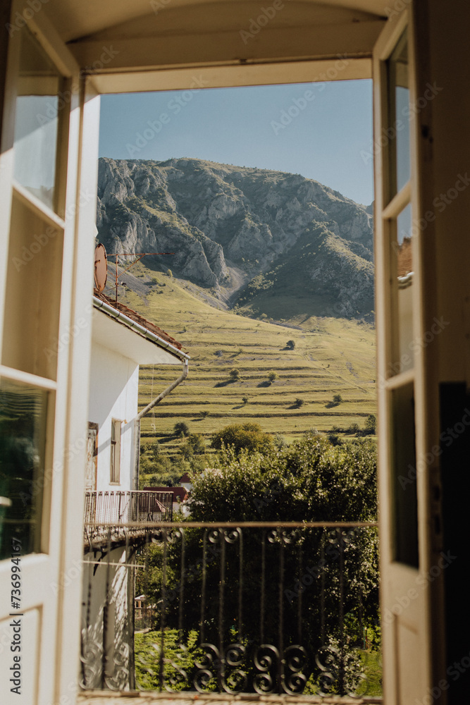 Iconic view from balcony over the Piatra Secuiului Cliff. Charming view over the meadow from a window. Iconic view from balcony over the Piatra Secuiului Cliff. Charming view over the meadow from a window.