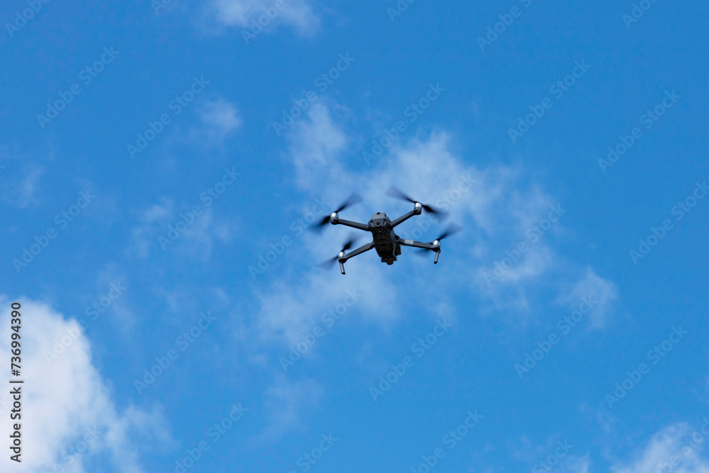 Modern quadcopter flies against the blue sky. Copy space. Modern quadcopter flies against the blue sky. Copy space.