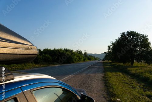 Family travel car with roof rack on a mountain road.