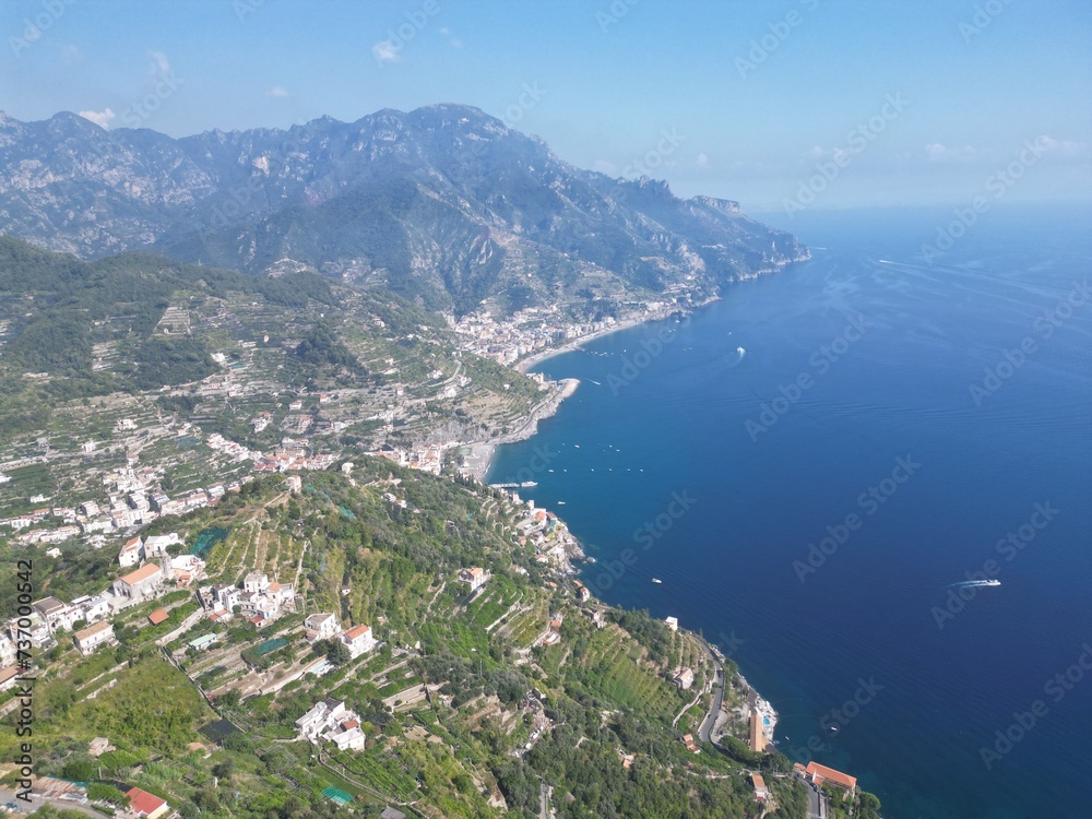 drone photo aerial view of Ravello, Amalfi coast, Campania, Lattari mountains in the background and blue sea with passing motorboats