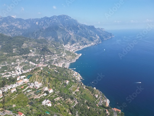 drone photo aerial view of Ravello, Amalfi coast, Campania, Lattari mountains in the background and blue sea with passing motorboats