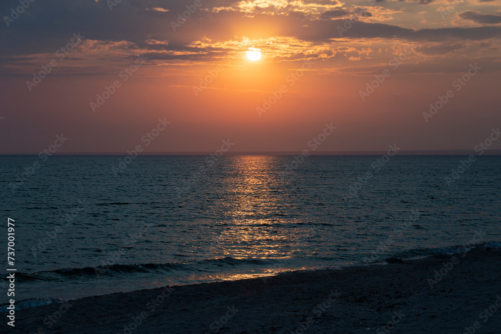 Beautiful setting sun with clouds over the sea, landscape.