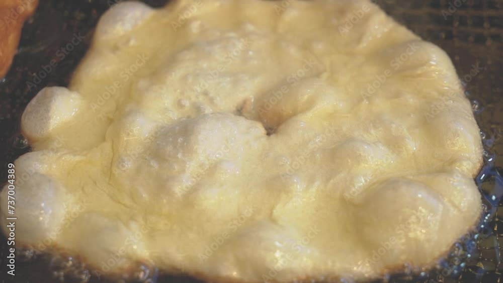 Process of making deep-fried italian donuts and pancake. Professional kitchen equipment. Deep fry italian donut dough using professional fryer. Slow motion close up oil boiling preparing big donuts Process of making deep-fried italian donuts and pancake. Professional kitchen equipment. Deep fry italian donut dough using professional fryer. Slow motion close up oil boiling preparing big donuts