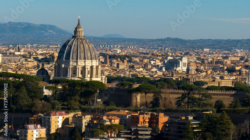 Closeup of the dome of the Papal Basilica of Saint Peter in the Vatican located in Rome, Italy. It's the largest church in the world. In the background there is the Vittoriano and Venezia square.