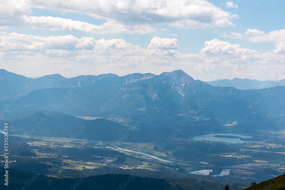 Panoramic view of Lake Faak surrounded by majestic mountain peaks of Karawanks and Julian Alps. Wanderlust on Gerlitzen Alpe, Carinthia, Austria. Idyllic hiking trail in Austrian Alps in summer Panoramic view of Lake Faak surrounded by majestic mountain peaks of Karawanks and Julian Alps. Wanderlust on Gerlitzen Alpe, Carinthia, Austria. Idyllic hiking trail in Austrian Alps in summer