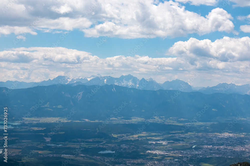 Panoramic view of Lake Faak surrounded by majestic mountain peaks of Karawanks and Julian Alps. Wanderlust on Gerlitzen Alpe,  Carinthia, Austria. Idyllic hiking trail in Austrian Alps in summer