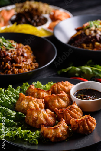Korean food. Fried gyoza dumplings. on a black wooden background.