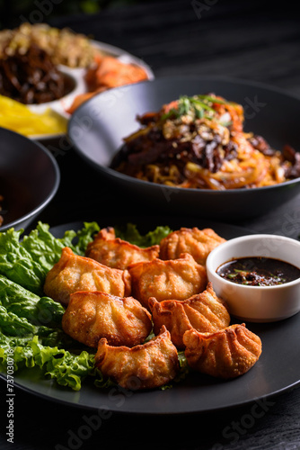 Korean food. Fried gyoza dumplings. on a black wooden background. © Anatoliy Krygin