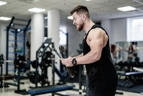 Handsome man with beard is engaged in gym