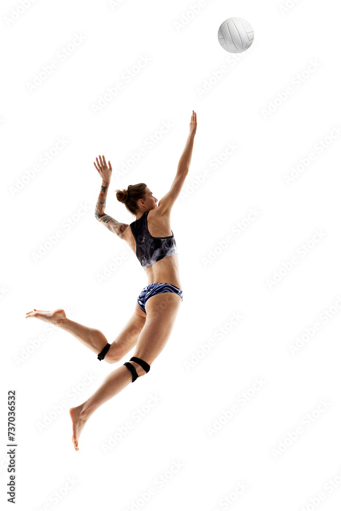 Obraz premium Dynamic portrait of woman, skilled, professional volleyball player training hits ball against white studio background. Concept of sport games, movement, championship, power and strength.