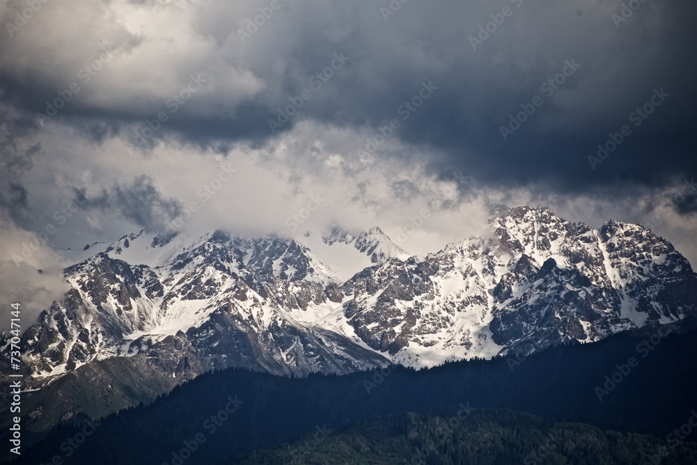 Beautiful view to the snowy winter mountain tops cloudy sky 