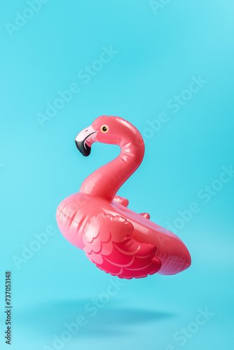 Inflatable pool toy flamingo on a blue background. Minimal summer concept.