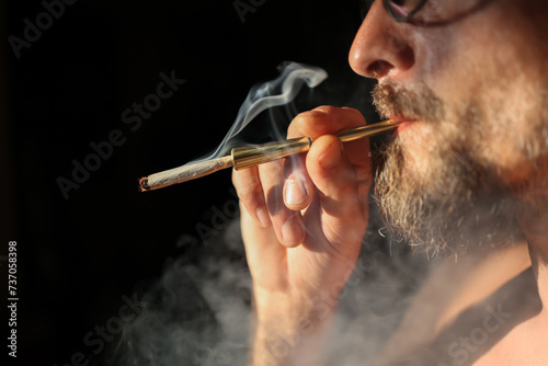 unrecognizable person smoking a lit marijuana cigarette.