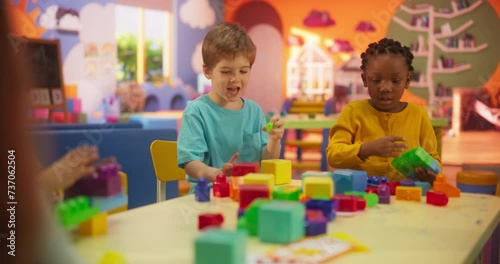 Portrait of Adorable Stylish Children Playing Together in a Kids Room at Shopping Mall. Talented Multiethnic Kids Spending Productive Time in Daycare, Playing with Colorful Construction Block Toys photo