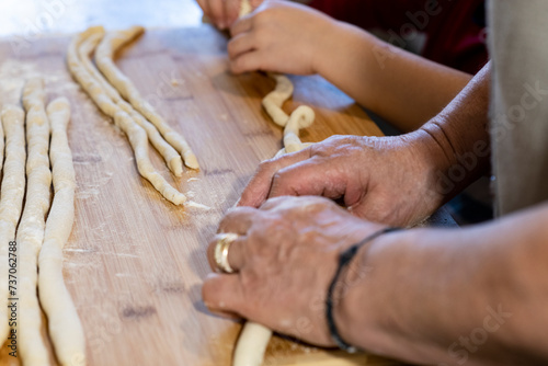 grandmother and granddaughter prepare homemade pasta called "gnocchi"