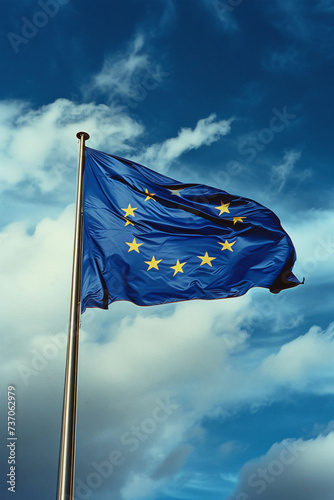 the european union flag blowing at a blue sky