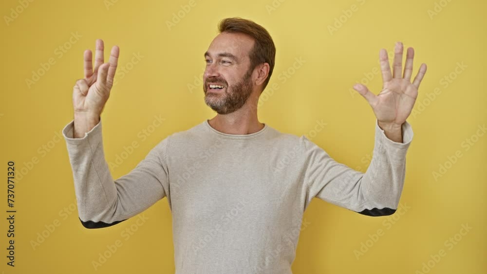 Cheerful middle-aged hispanic man confidently standing, pointing up with fingers, showing number nine, with a big smile on yellow isolated background Cheerful middle-aged hispanic man confidently standing, pointing up with fingers, showing number nine, with a big smile on yellow isolated background